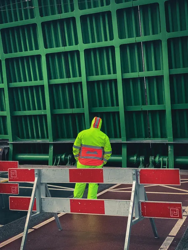 Medewerker in hesje bij een afgesloten brug in Amsterdam